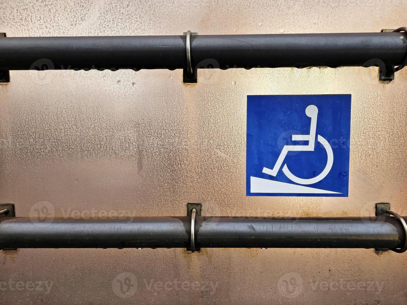 Disabled Ramp Access Sign with metal handrail on tram station. photo