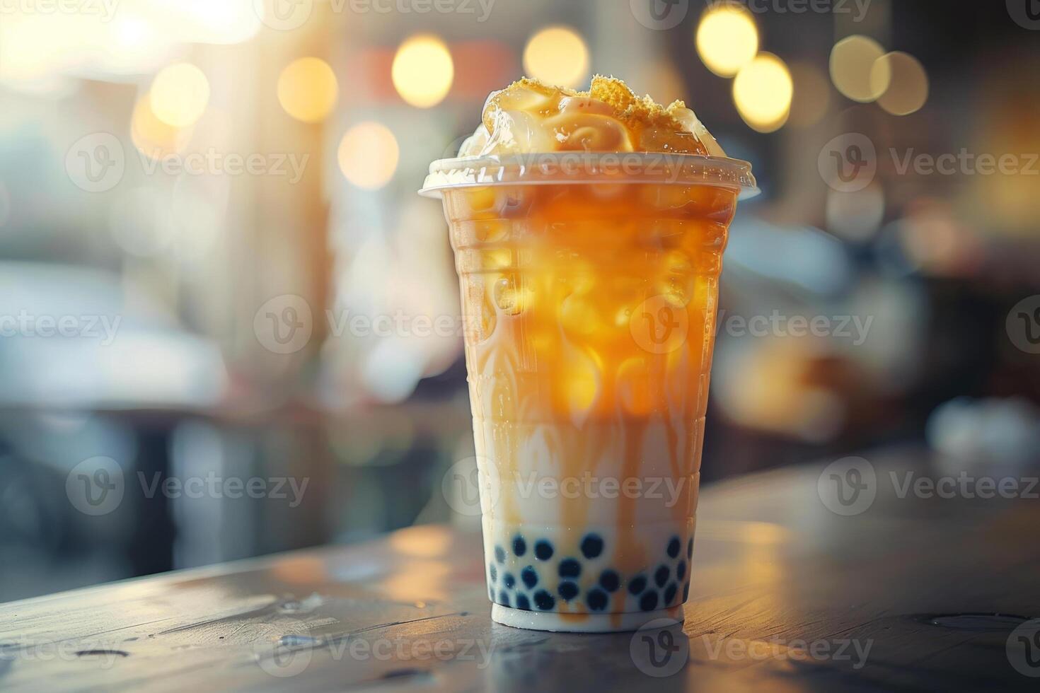 Bubble milk tea with tapioca pearls in plastic glass. Cold asian drink on table in street cafe, night market photo