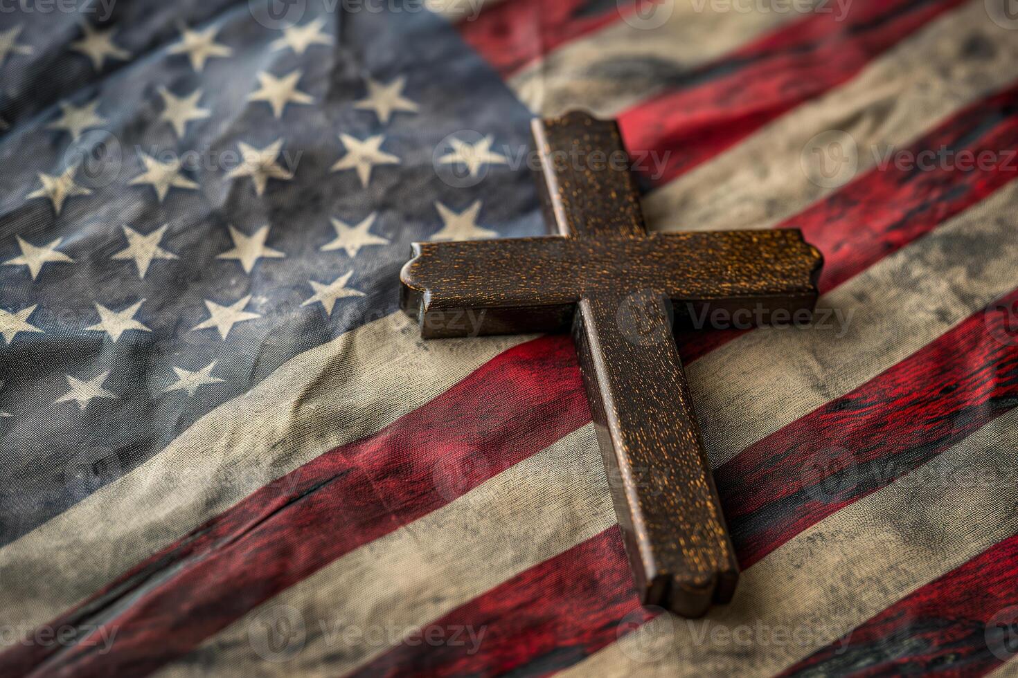 A wooden cross rests atop an American flag, symbolizing a blend of faith and patriotism. photo