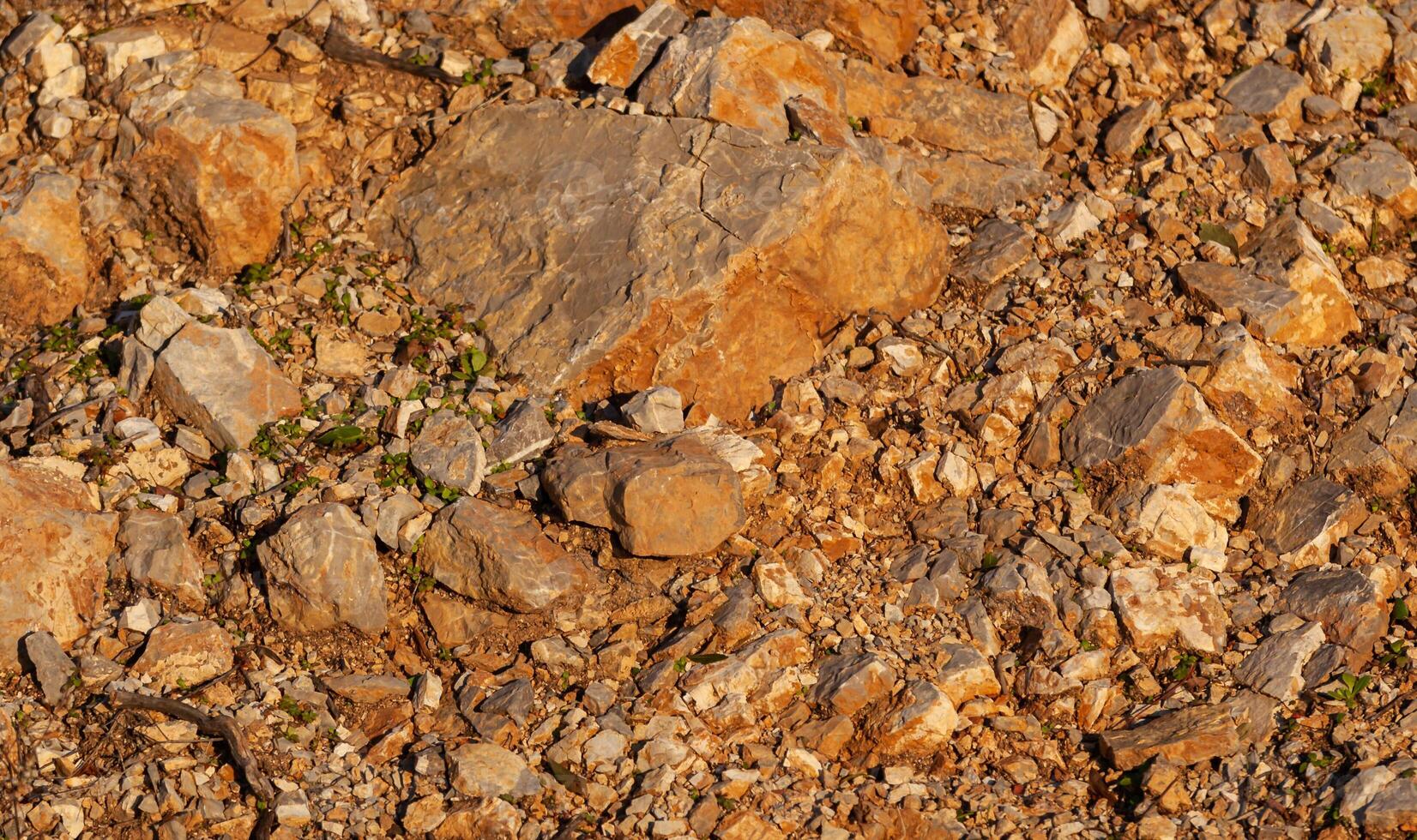 Red rocks of different shapes and sizes on the ground. Orange texture. Background. For text. For banner. Horizontal photo