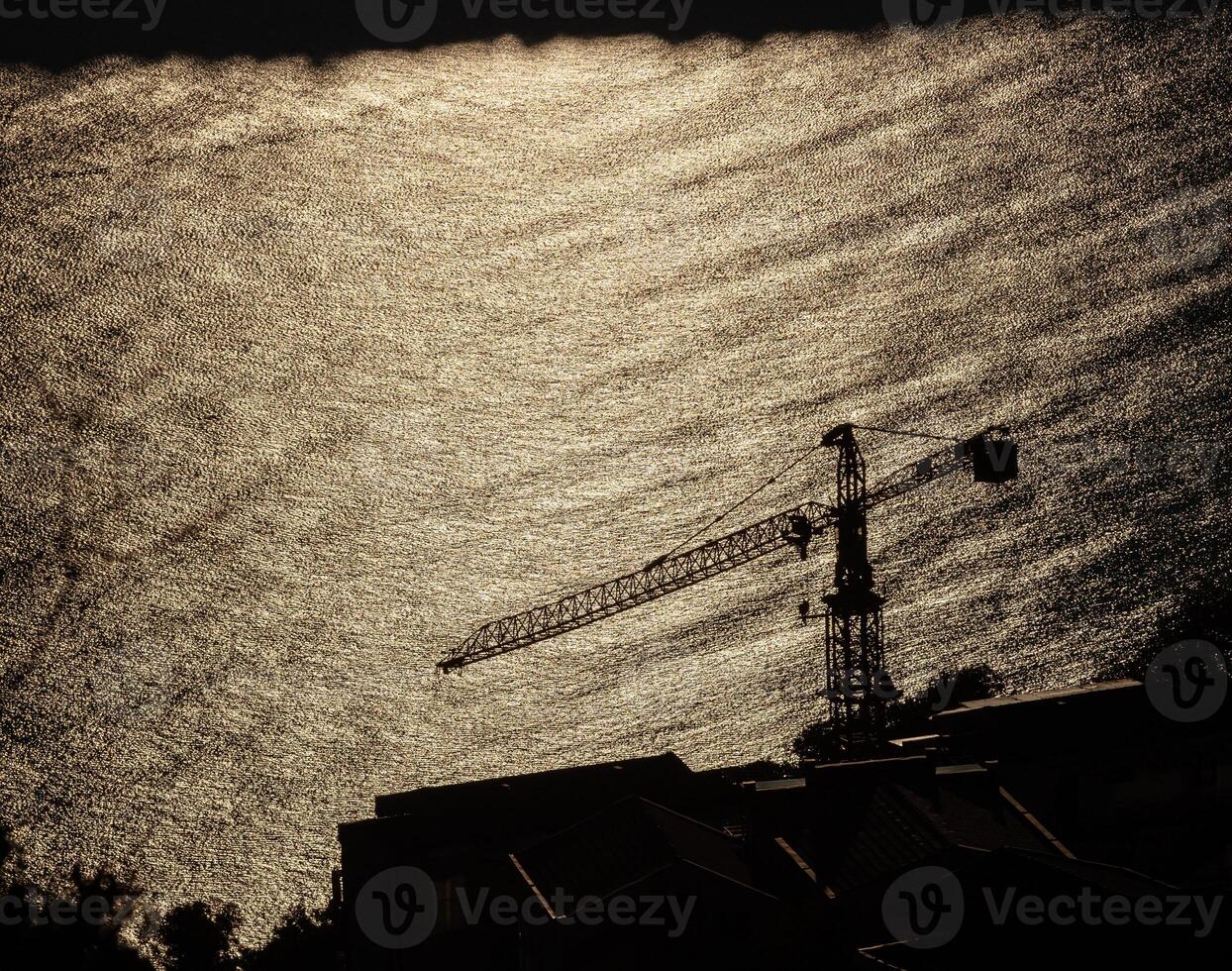 Summer landscape of the Adriatic coastline with Jaz beach near Budva, Montenegro. Sun high in the sky. Residential buildings and a construction crane. Horizontal. photo