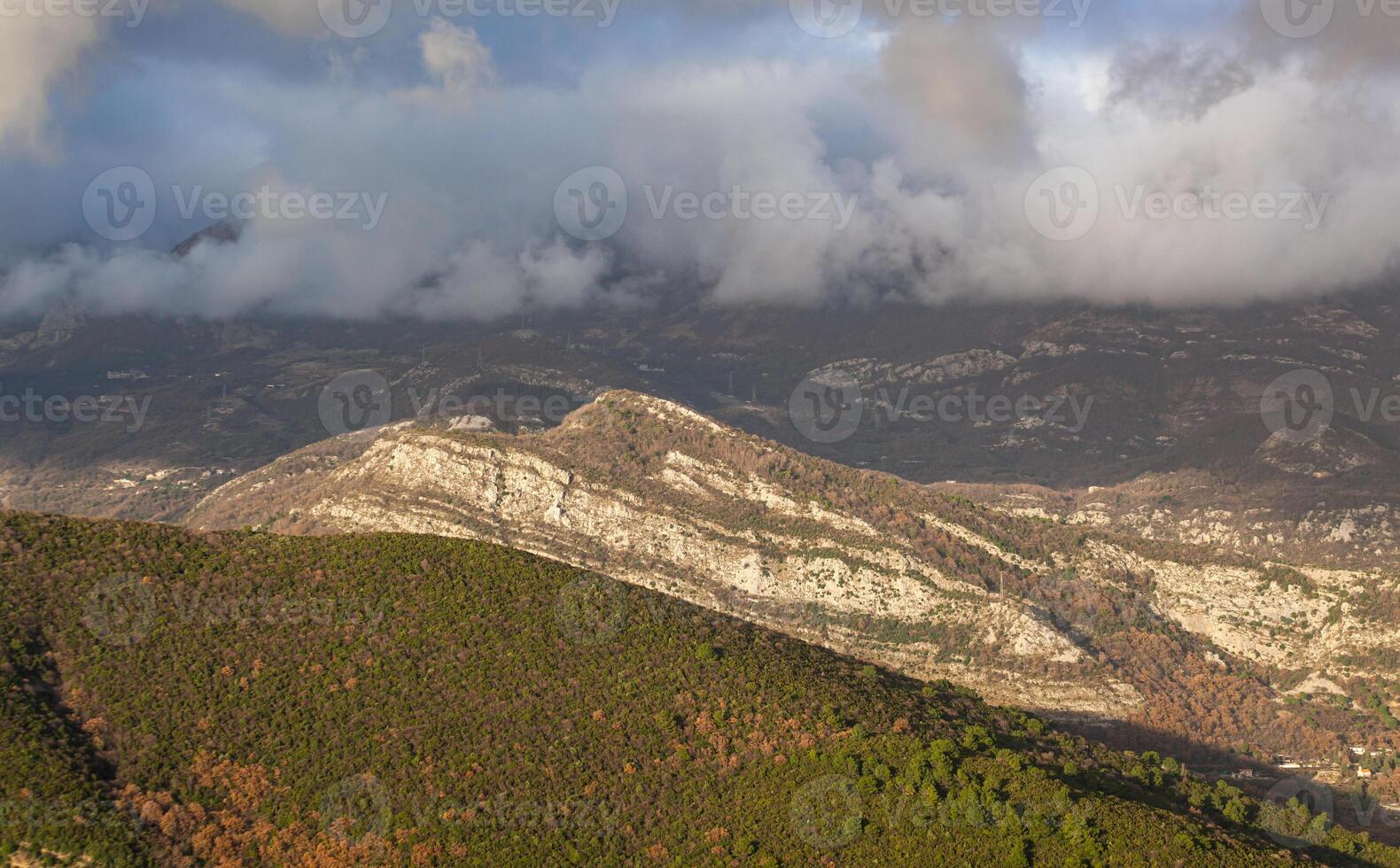 Spring in the mountains, beautiful mountain landscape. View of the mountain range and green trees. Summer, autumn and winter. Budva, Montenegro. Europe. Background. For text. Banner. Vertical photo