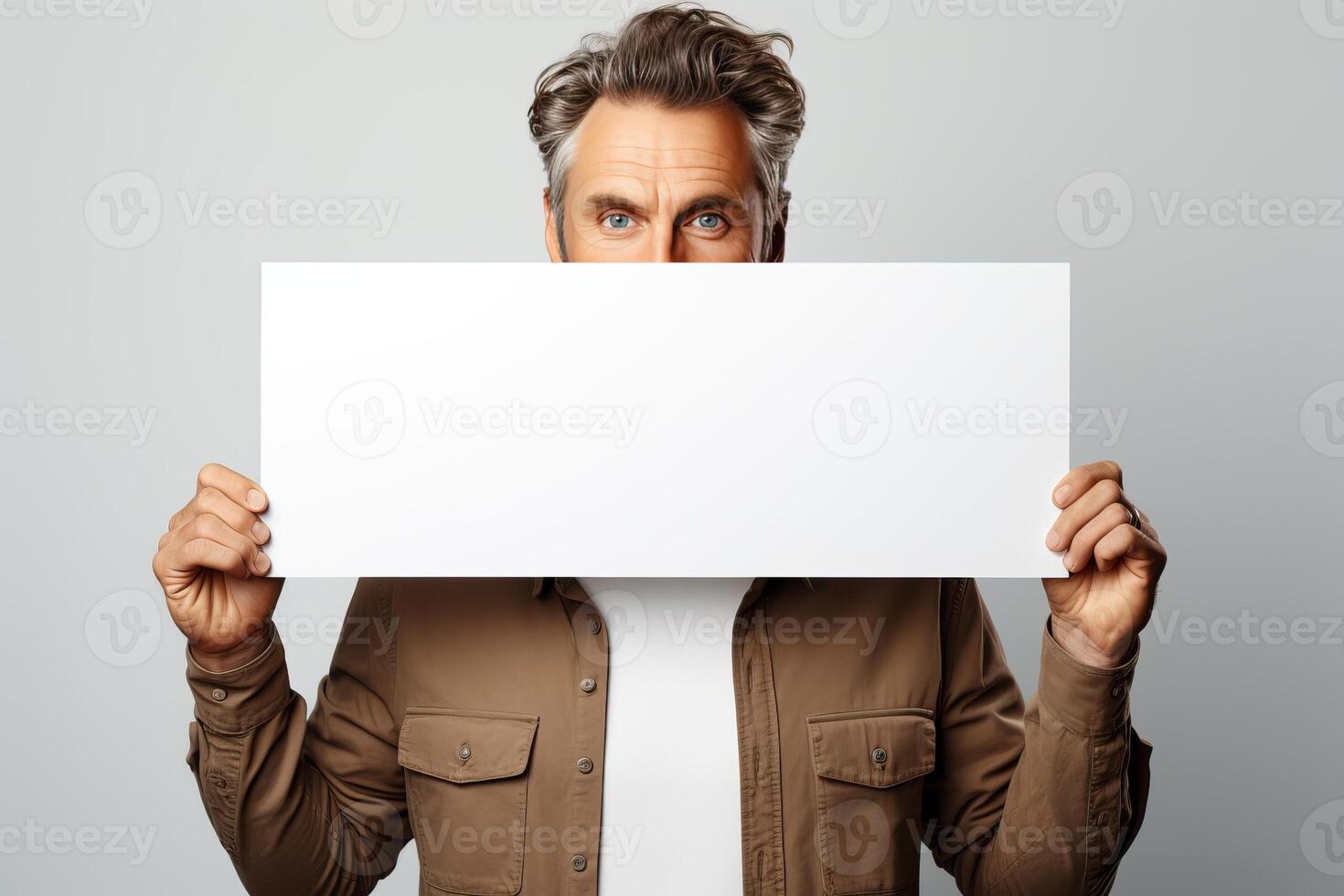 retrato de un hombre participación un blanco horizontal sábana de papel con un sitio para escritura y Bosquejo. foto