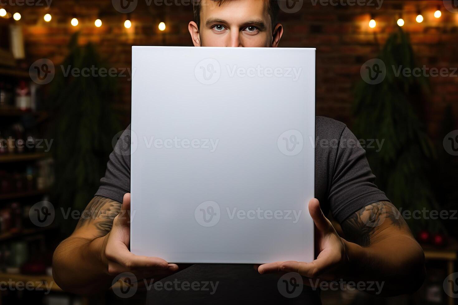a young businessman guy holds a white sheet of paper in his hands on the background of a cafe. photo