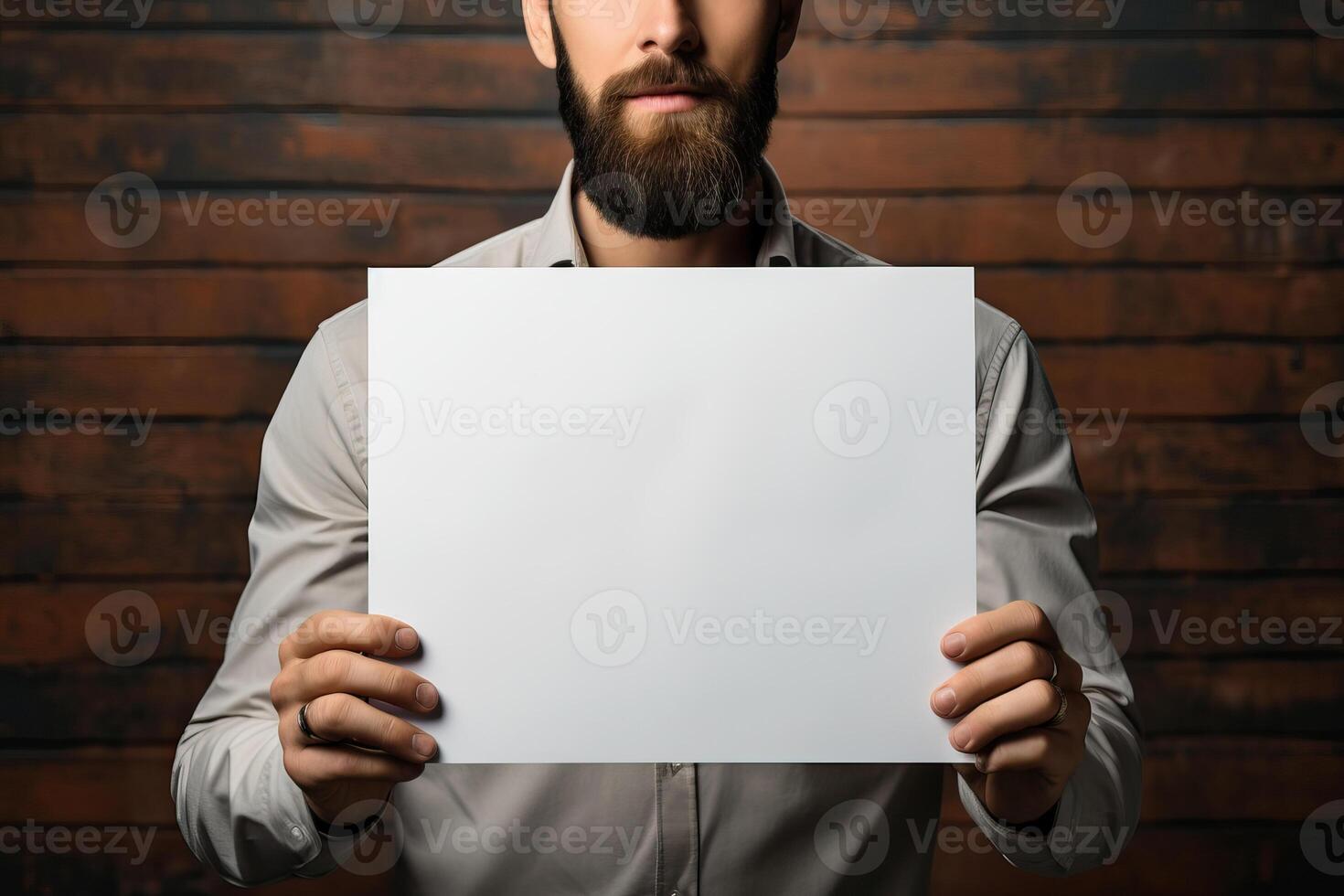 a middle-aged man holds a sheet of white paper mockup in his hands. photo