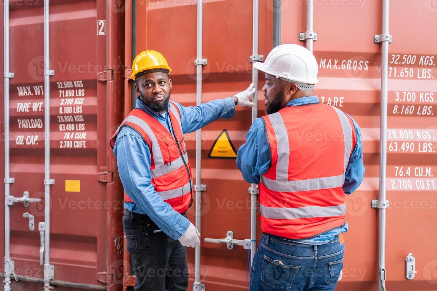 Portrait of Two African Engineer or foreman wears PPE checking container storage with cargo container background at sunset. Logistics global import or export shipping industrial concept. photo