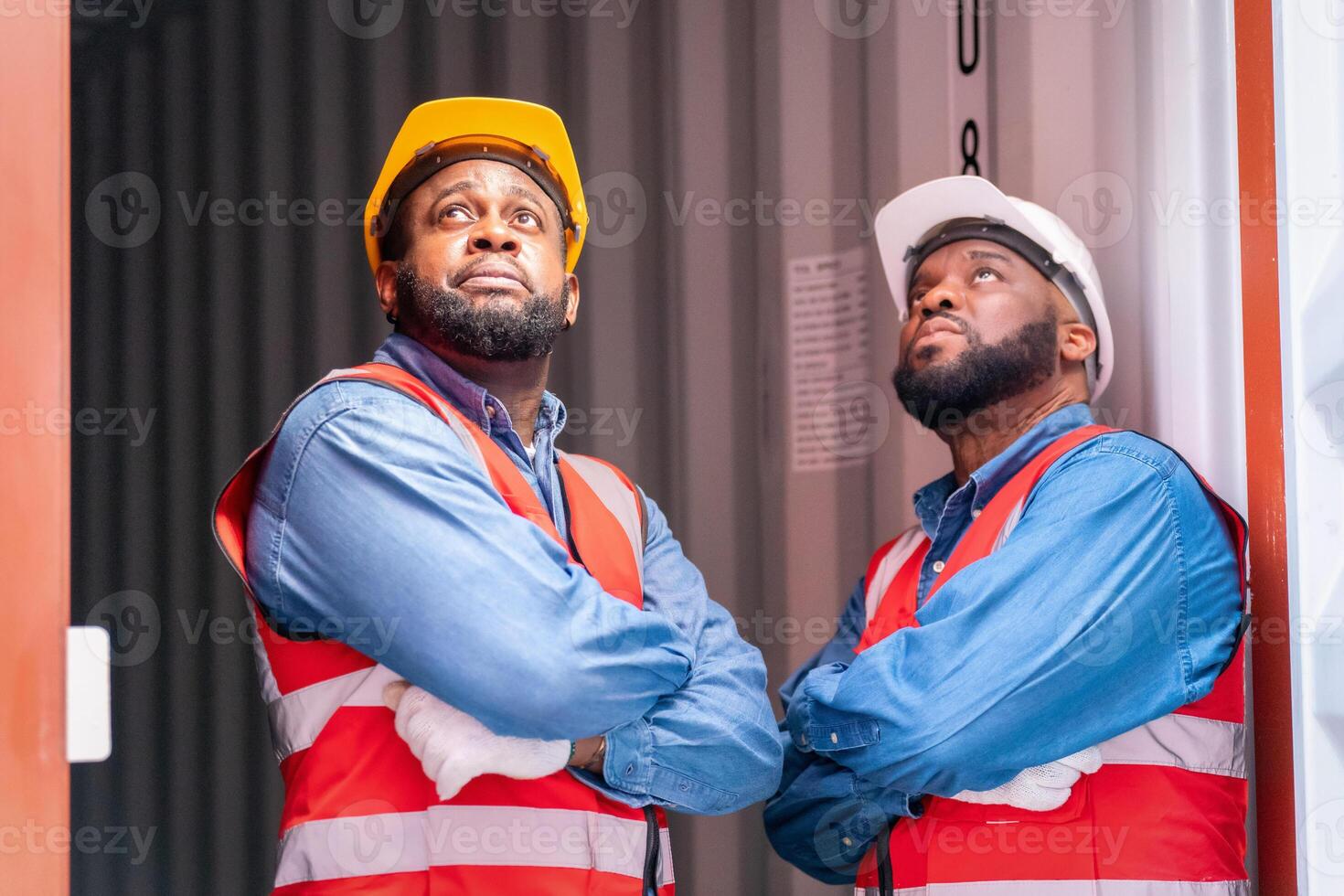 Portrait of Two African Engineer or foreman wears PPE pointing up the future  with cargo container background at sunset. Logistics global import or export shipping industrial concept. photo