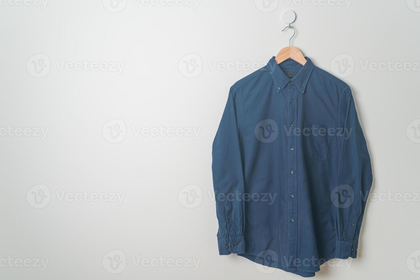 hanging shirt with wood hanger on wall photo