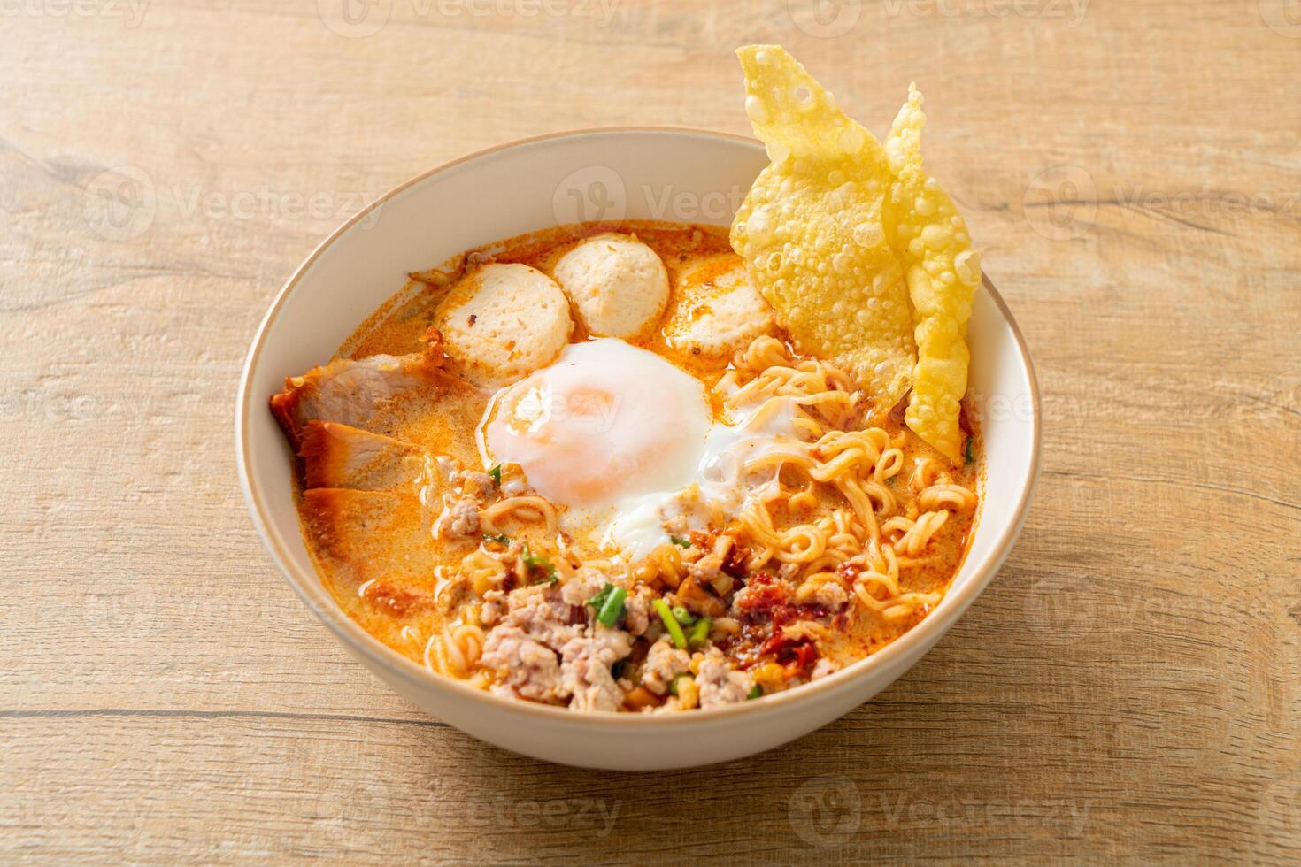 instant noodles with pork and meatballs in spicy soup photo