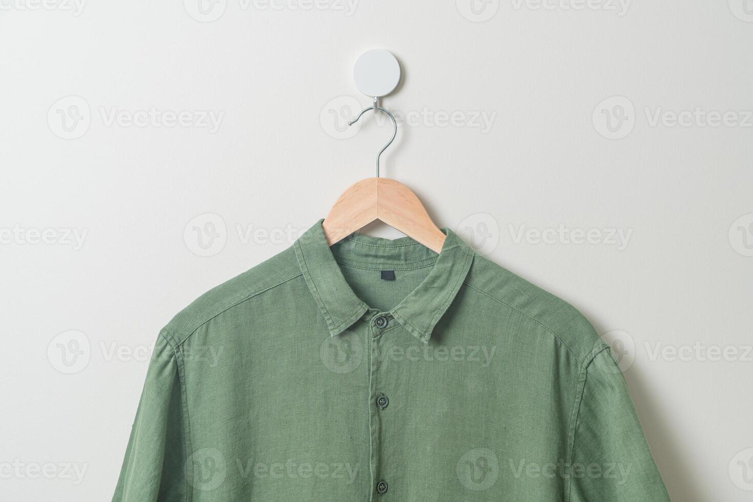 hanging shirt with wood hanger on wall photo