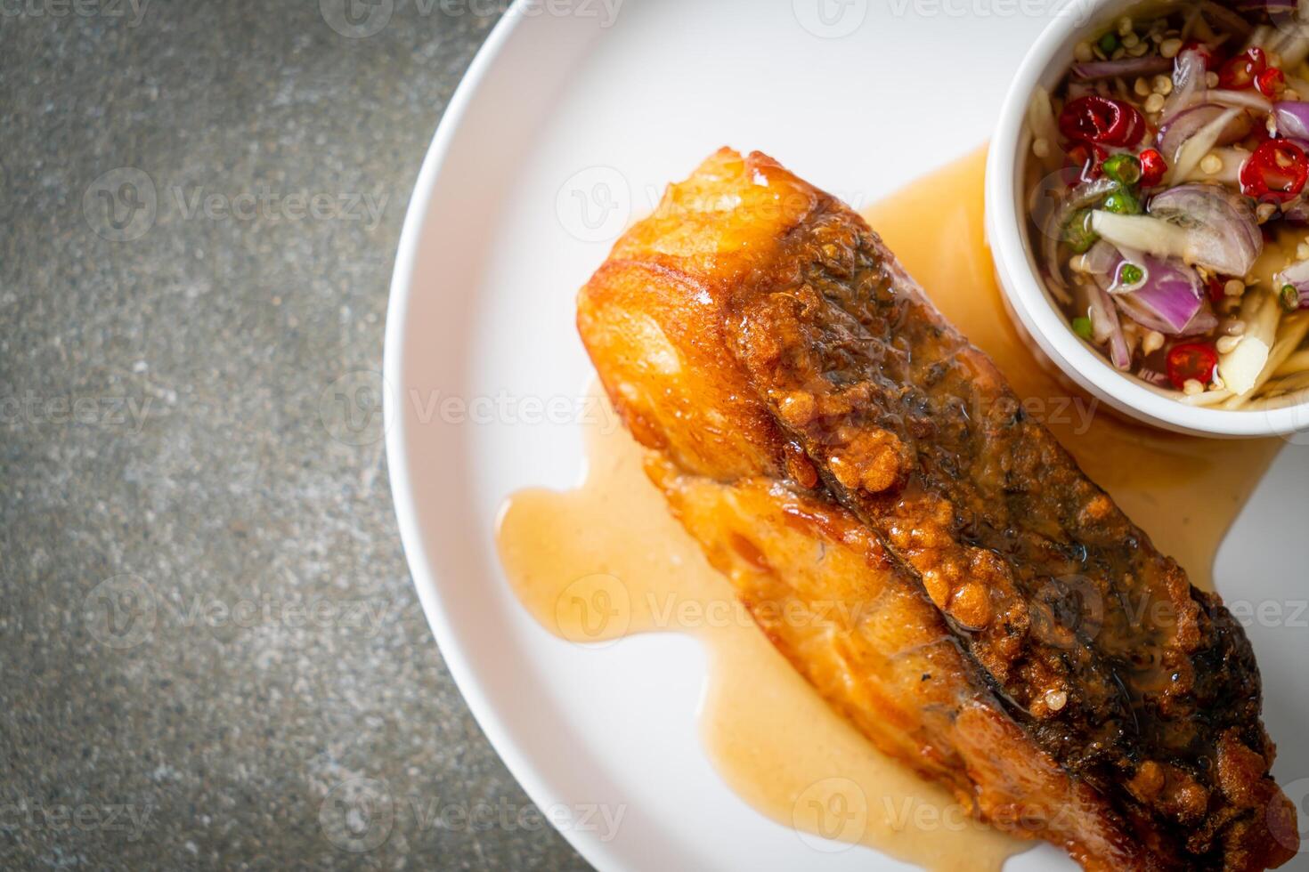 fried snapper fish with fish sauce and spicy salad photo