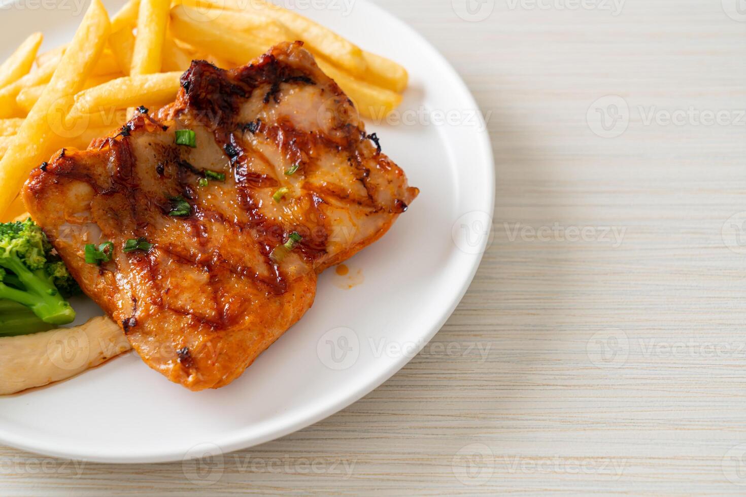 grilled chicken steak with potato chips or french fries photo