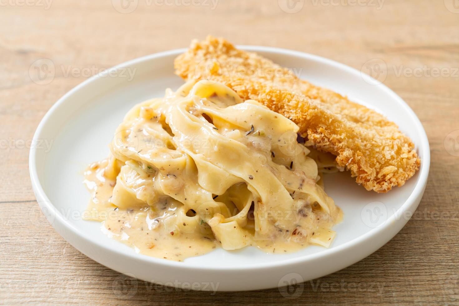 fettuccine pasta white cream sauce with fried fish photo