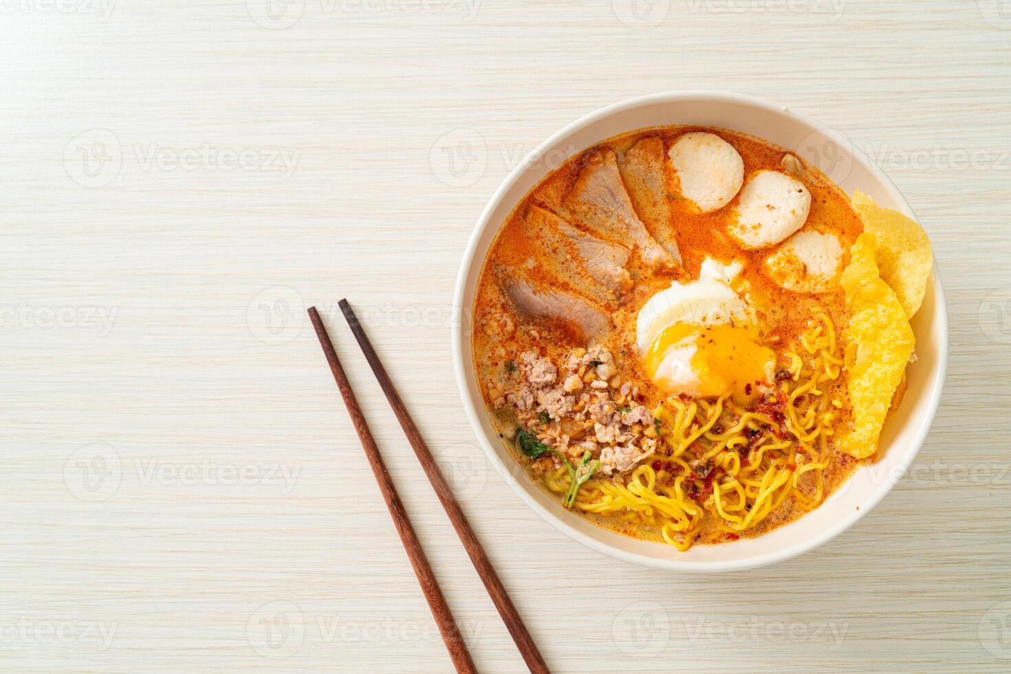 egg noodles with pork and meatball in spicy soup photo
