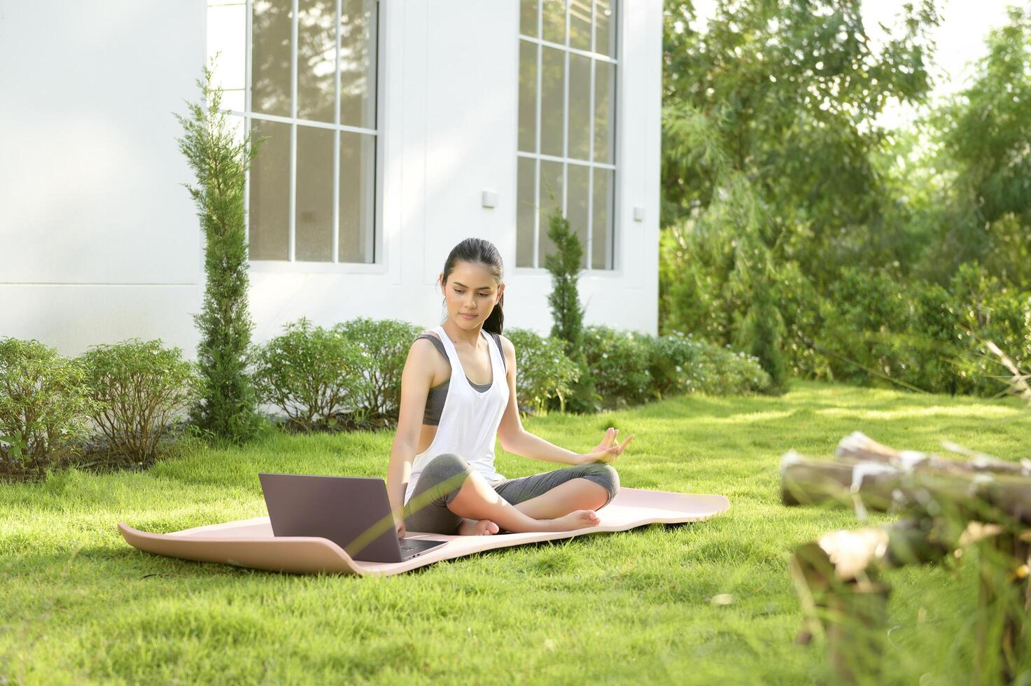 Young woman in sportswear doing meditation practice and yoga outdoor, healthy lifestyle, Mental health concept. photo
