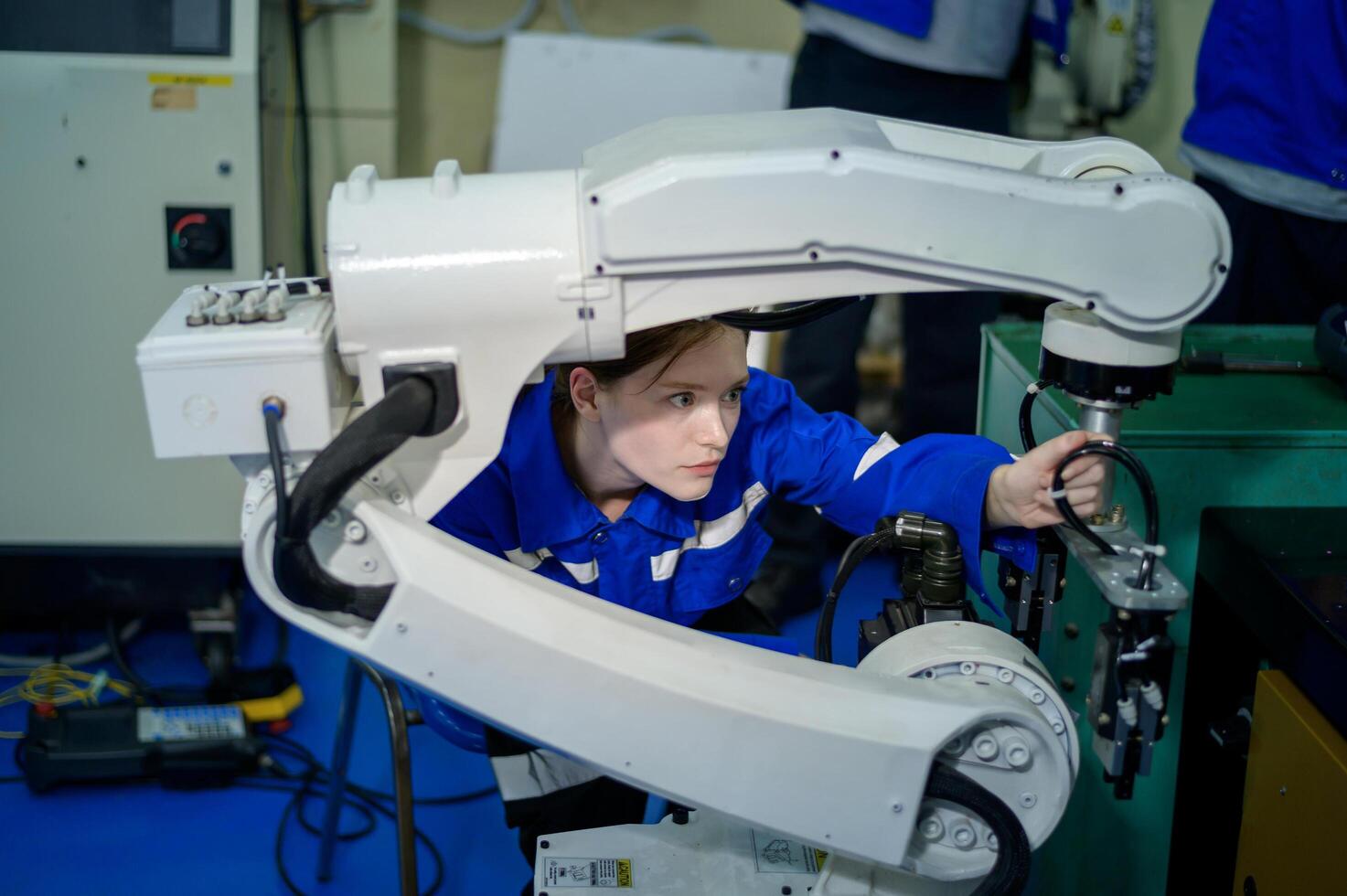 Female Robotics engineer working with Programming and Manipulating Robot Hand, Industrial Robotics Design, High Tech Facility, Modern Machine Learning. Mass Production Automatics. photo