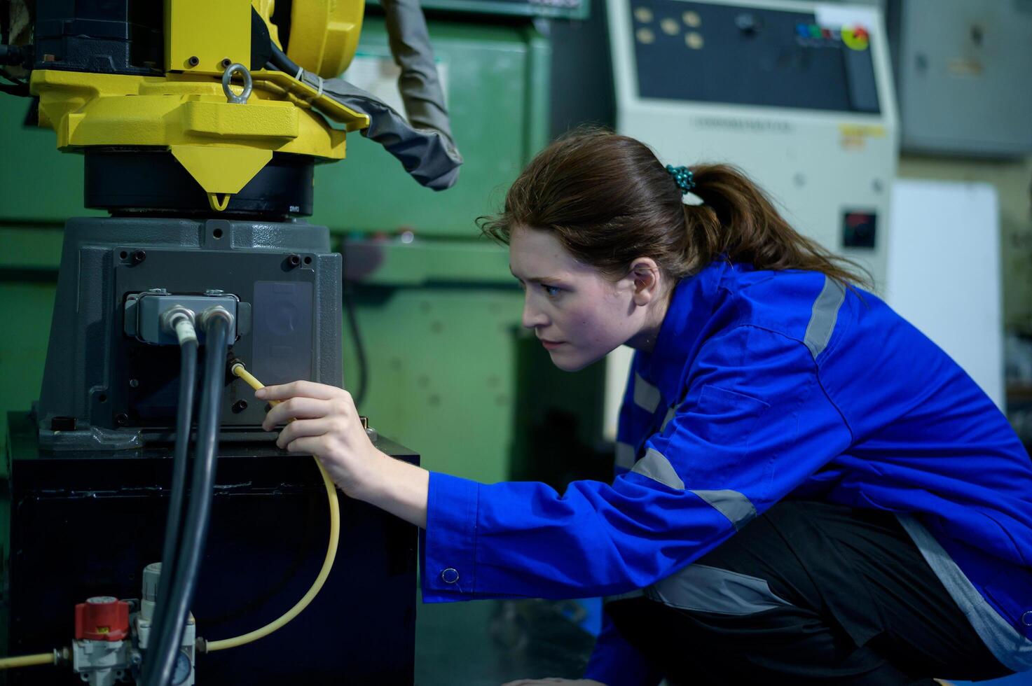 Female Robotics engineer working with Programming and Manipulating Robot Hand, Industrial Robotics Design, High Tech Facility, Modern Machine Learning. Mass Production Automatics. photo