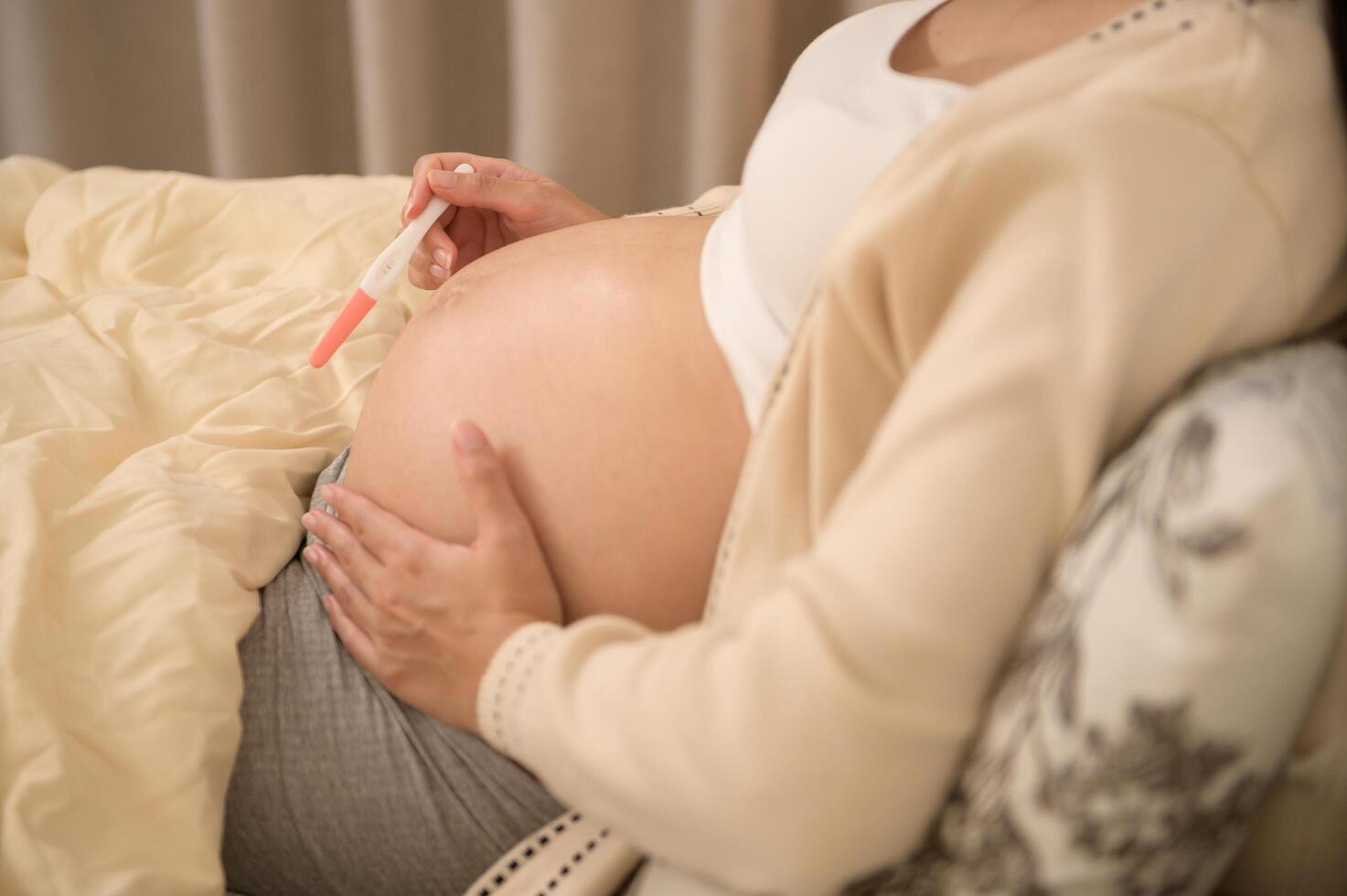 Beautiful pregnant woman holding positive pregnancy test, fertility infertility treatment, IVF, future maternity concept photo