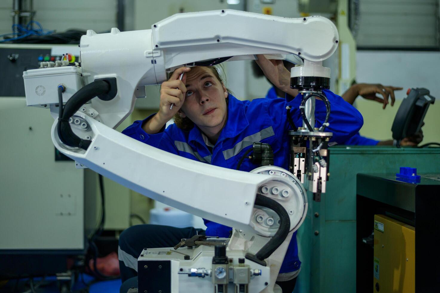 Male Robotics engineer working with Programming and Manipulating Robot Hand, Industrial Robotics Design, High Tech Facility, Modern Machine Learning. Mass Production Automatics. photo