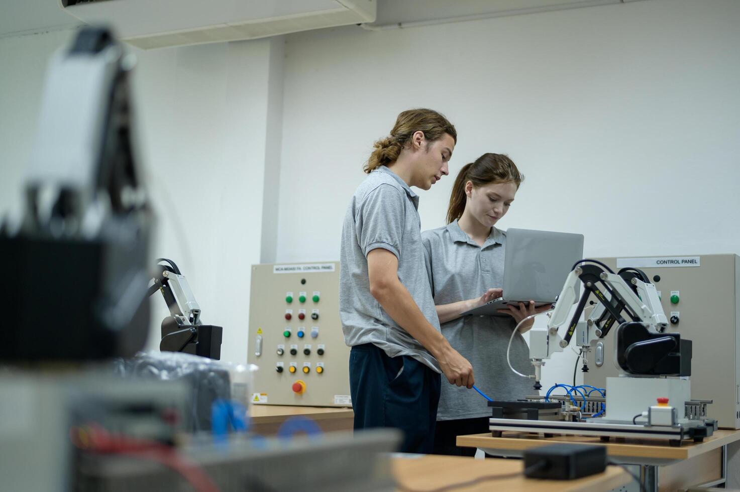 aprendiz robótica ingeniero aprendizaje con programación y manipulando robot mano, industrial robótica diseño, alto tecnología instalación, moderno máquina aprendiendo. masa producción automáticas. foto