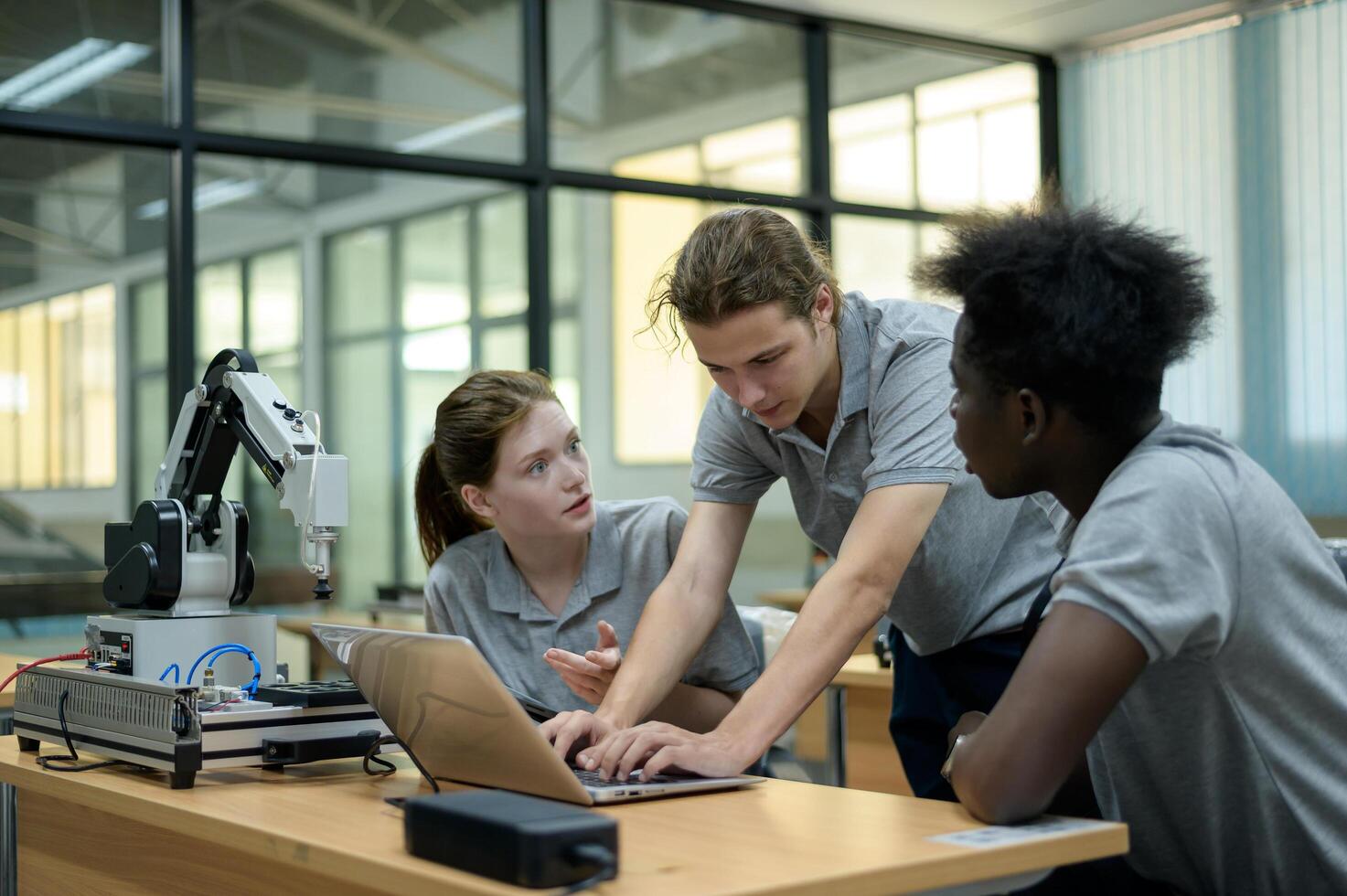 Trainee Robotics engineer learning with Programming and Manipulating Robot Hand, Industrial Robotics Design, High Tech Facility, Modern Machine Learning. Mass Production Automatics. photo