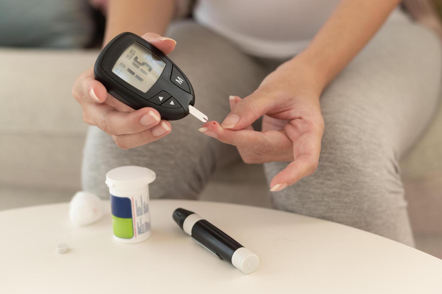Close up of woman checking blood sugar level by using Digital Glucose meter, health care, medicine, diabetes, glycemia concept photo