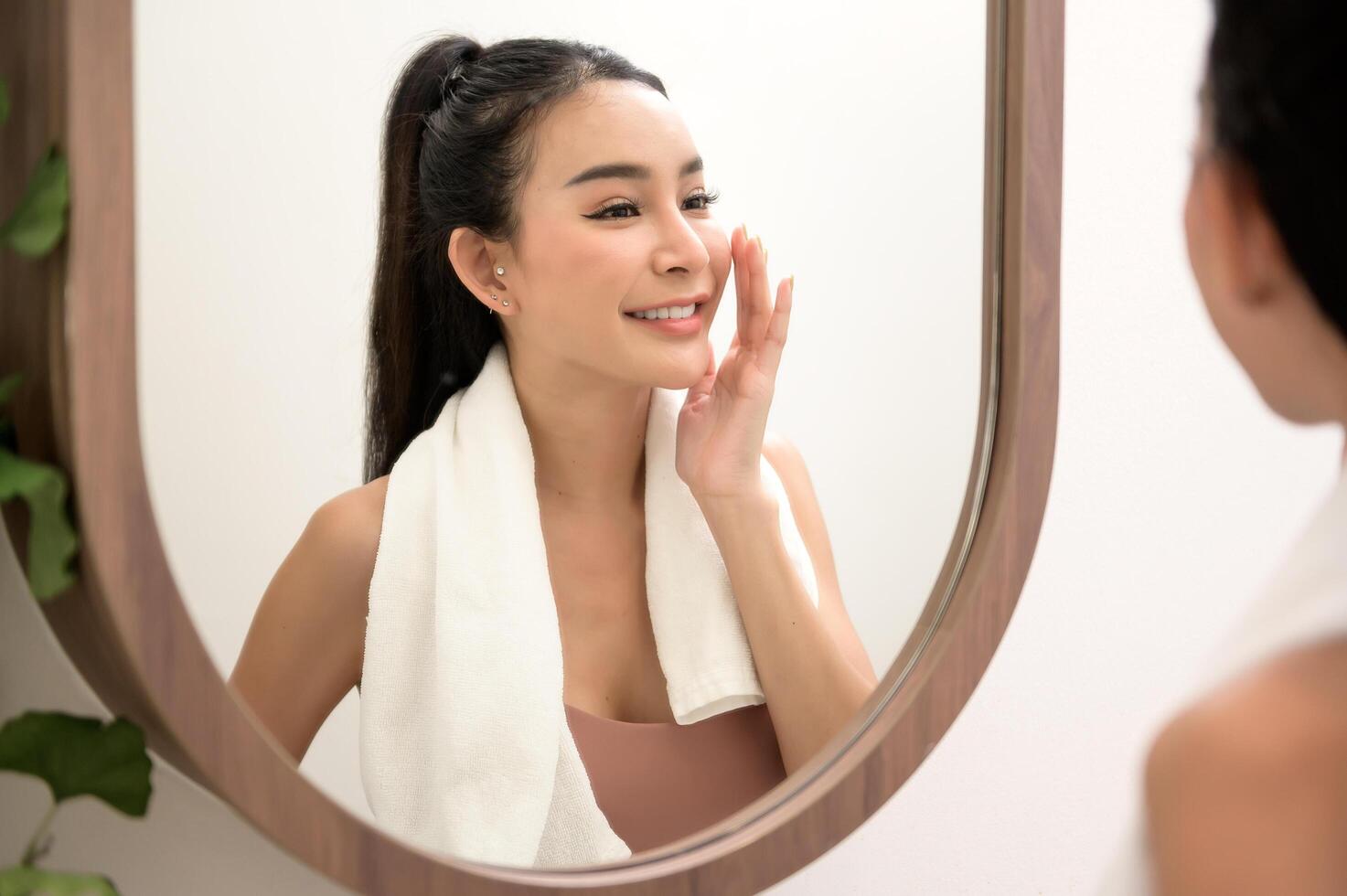 hermosa asiático mujer es Lavado y limpieza su cara foto