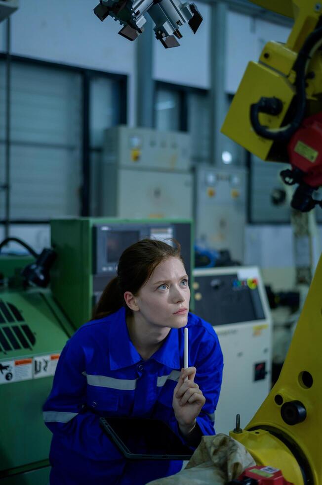 hembra robótica ingeniero trabajando con programación y manipulando robot mano, industrial robótica diseño, alto tecnología instalación, moderno máquina aprendiendo. masa producción automáticas. foto