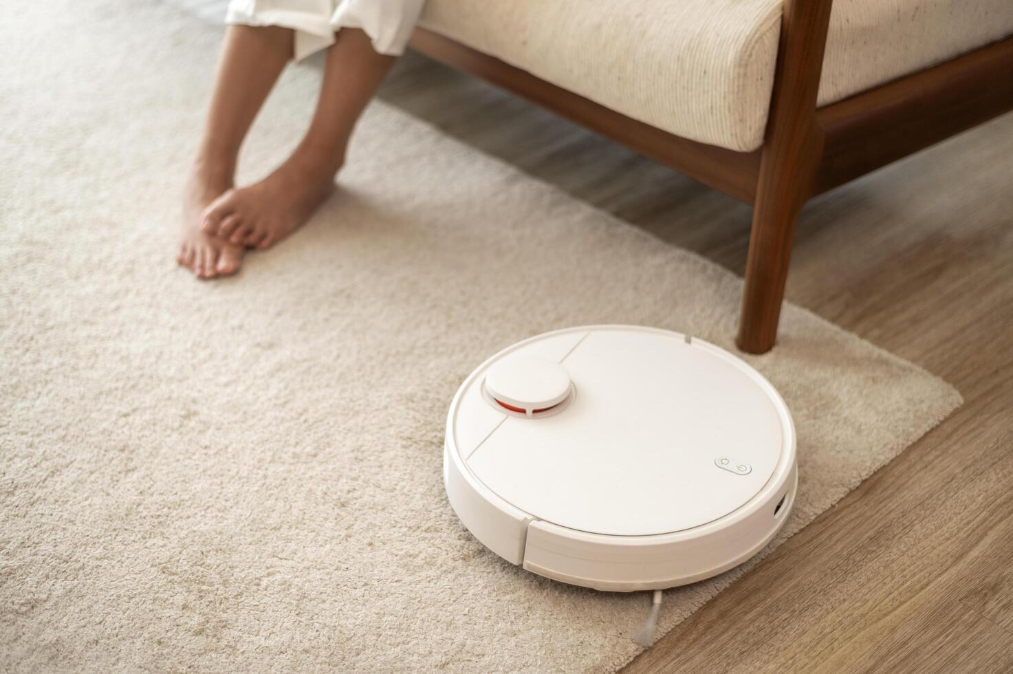 Close up of Robotic vacuum cleaner working in living room photo