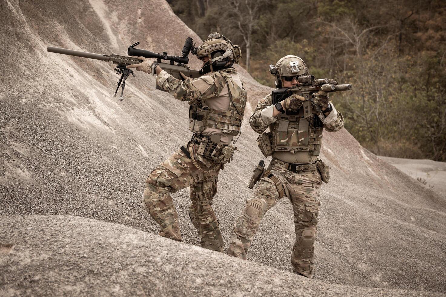 Soldiers in camouflage uniforms aiming with their riflesready to fire during military operation in the desert soldiers training  in a military operation photo