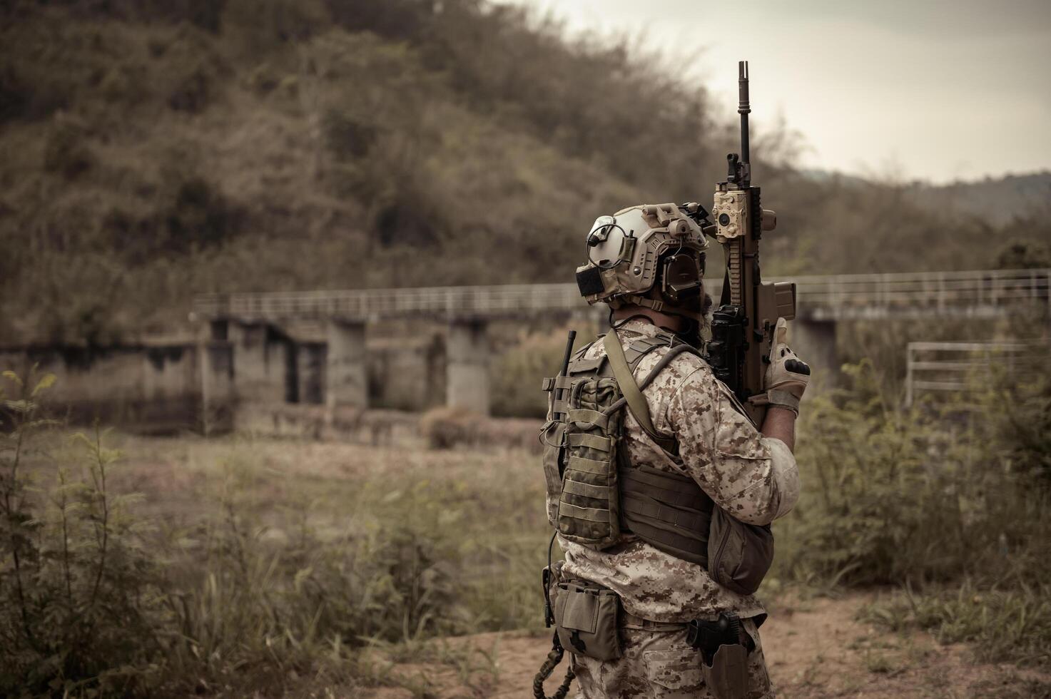 Soldiers  in camouflage uniforms aiming with their riflesready to fire during Military Operation in the forest soldiers training  in a military operation photo