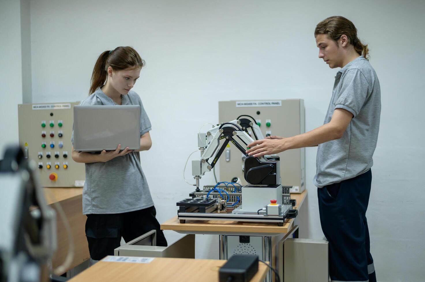 aprendiz robótica ingeniero aprendizaje con programación y manipulando robot mano, industrial robótica diseño, alto tecnología instalación, moderno máquina aprendiendo. masa producción automáticas. foto