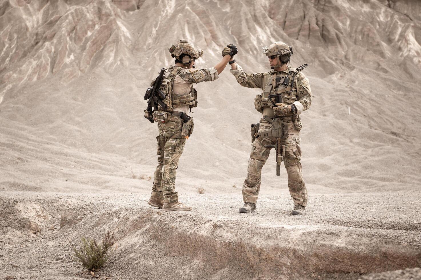 soldados en camuflaje uniformes puntería con su rifles listos a fuego durante militar operación en el Desierto soldados formación en un militar operación foto