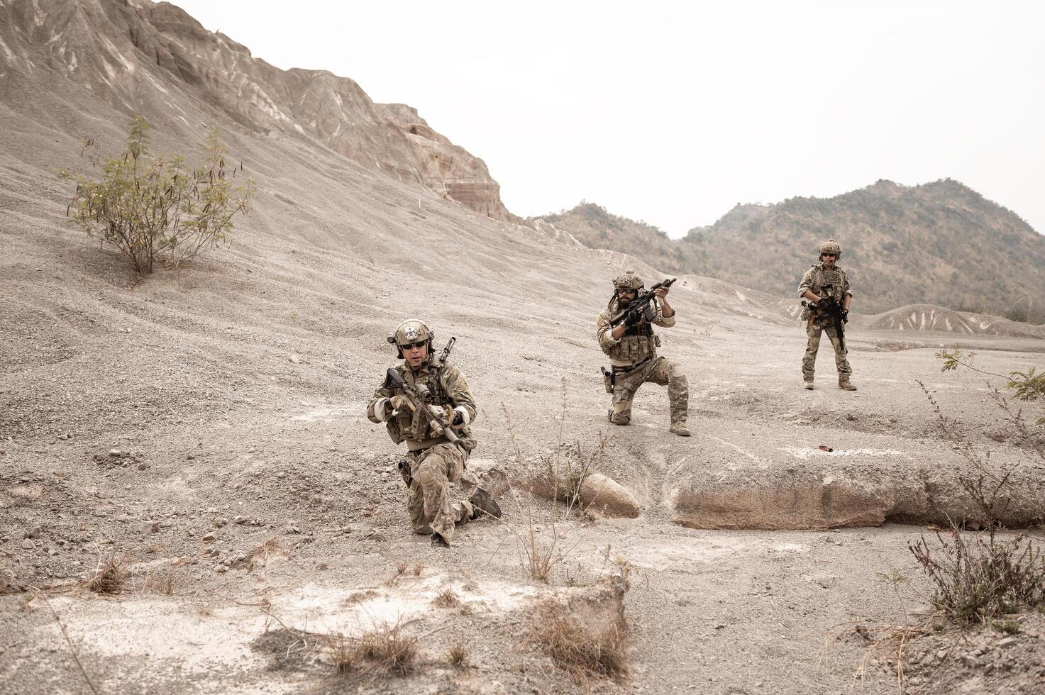 soldados en camuflaje uniformes puntería con su rifles listos a fuego durante militar operación en el Desierto soldados formación en un militar operación foto