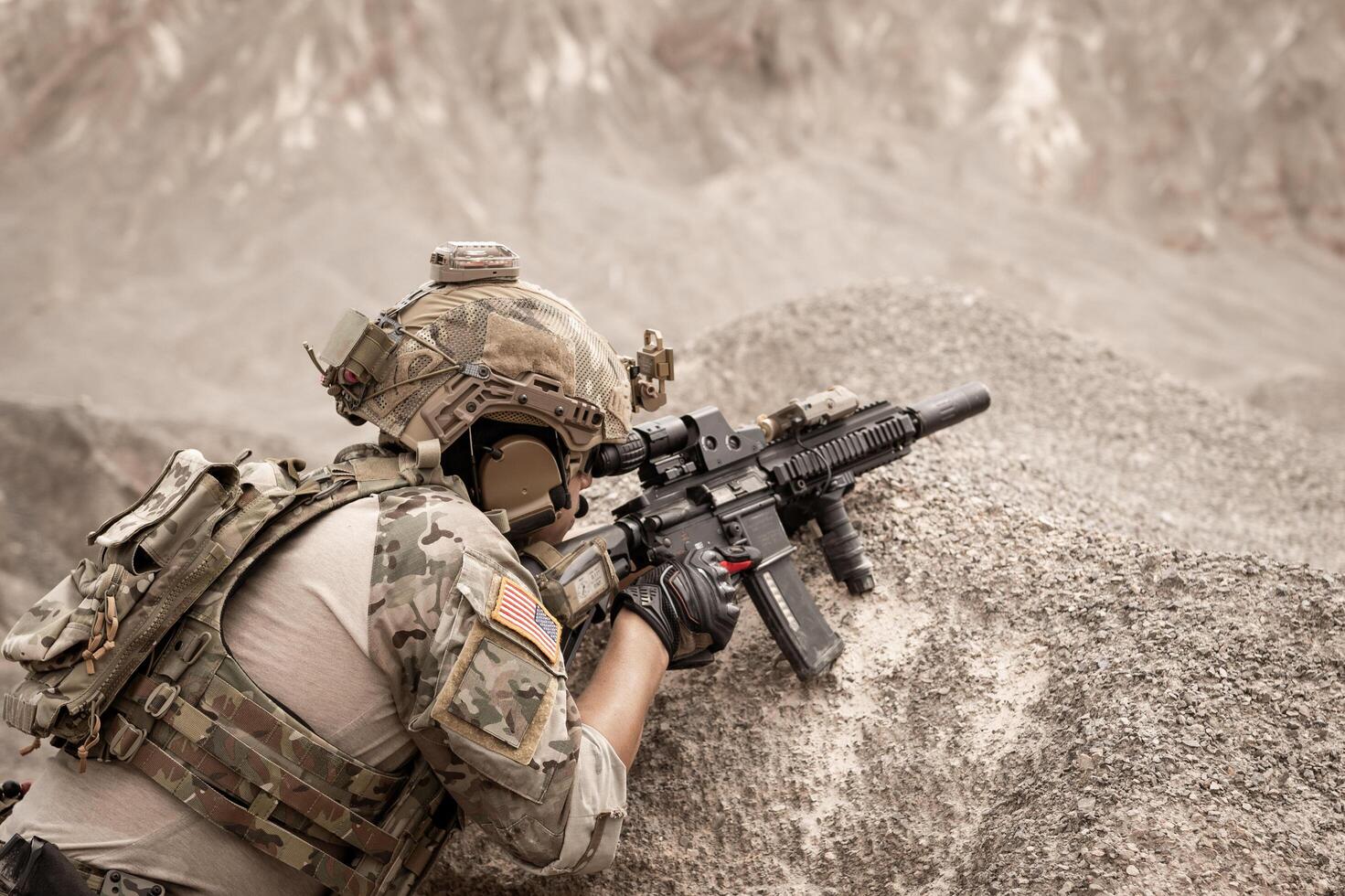 Soldiers in camouflage uniforms aiming with their riflesready to fire during military operation in the desert soldiers training  in a military operation photo