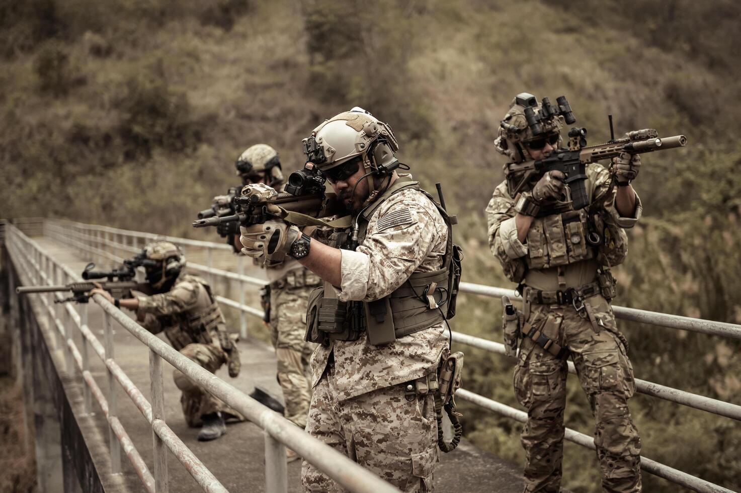 Soldiers  in camouflage uniforms aiming with their riflesready to fire during Military Operation in the forest soldiers training  in a military operation photo