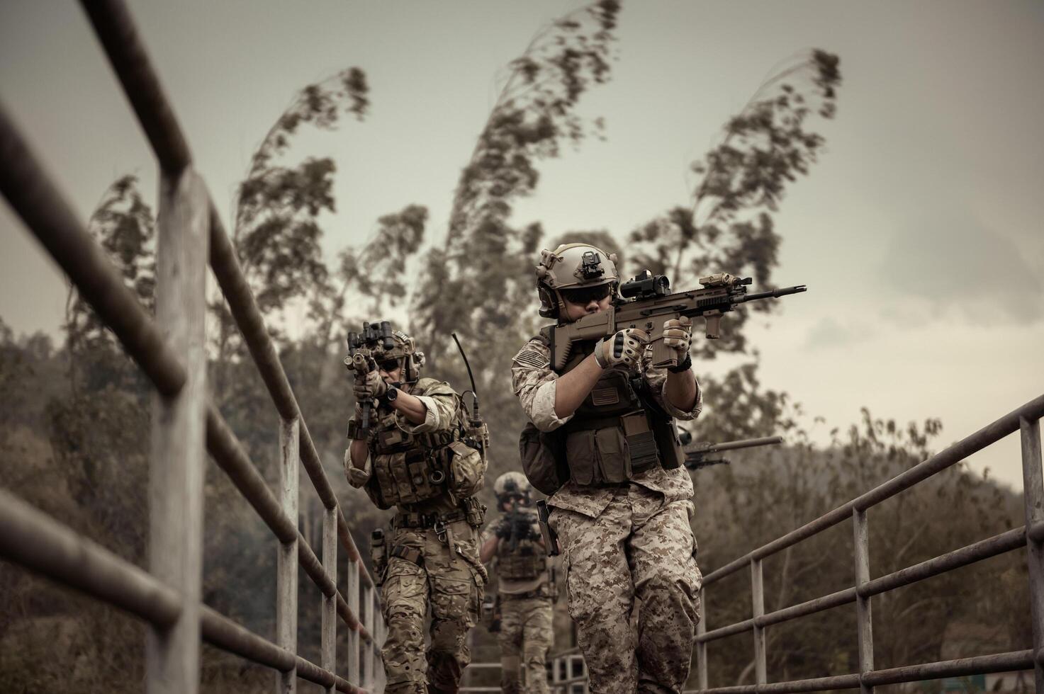 Soldiers  in camouflage uniforms aiming with their riflesready to fire during Military Operation in the forest  soldiers training  in a military operation photo