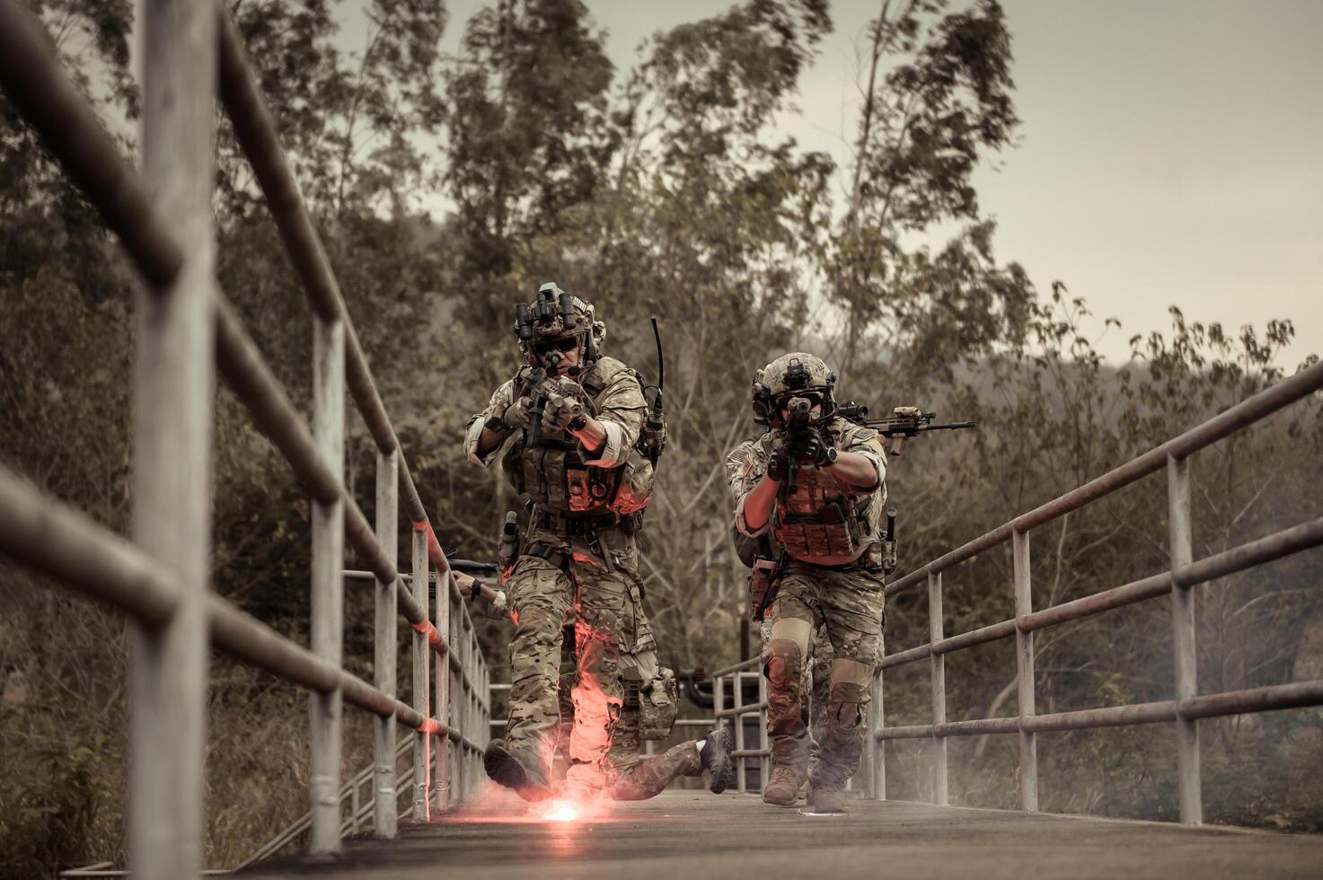 soldados en camuflaje uniformes puntería con su rifles listos a fuego durante militar operación en el bosque soldados formación en un militar operación foto