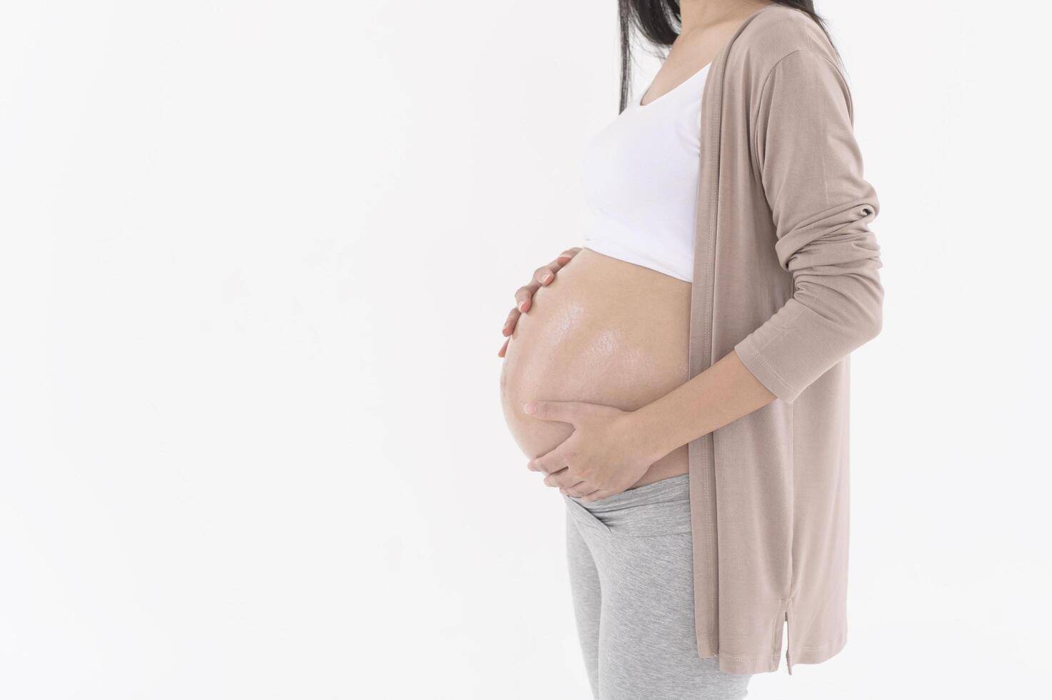 Beautiful pregnant woman applying moisturizing, stretch mark cream on belly, fertility infertility treatment, IVF, future maternity concept photo