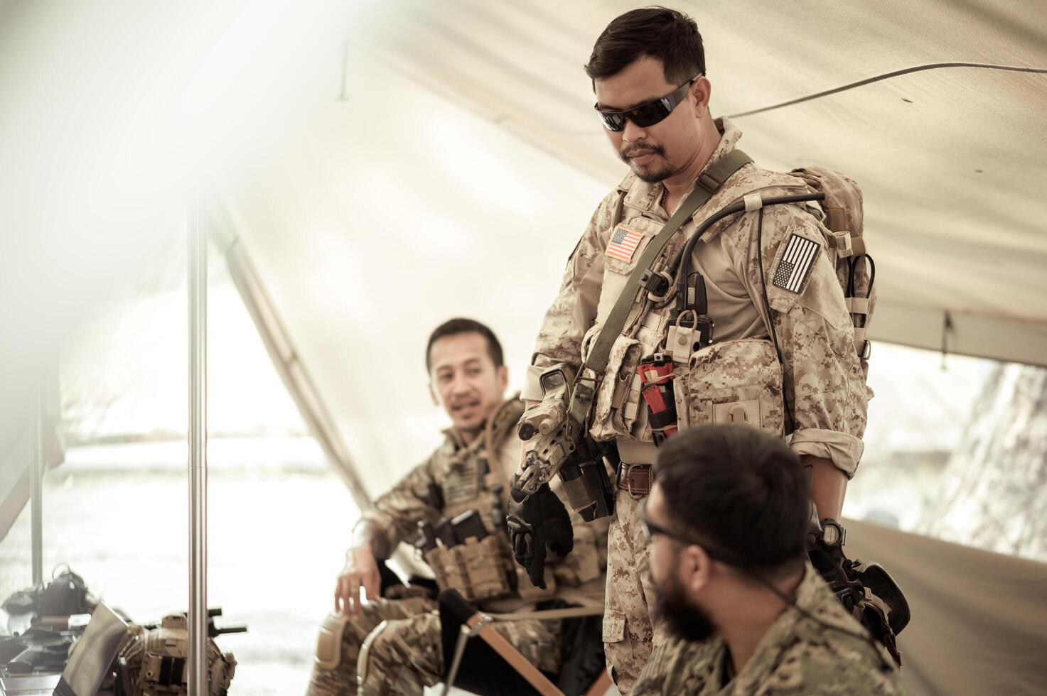 Soldiers in camouflage uniforms planning on operation in the camp, soldiers training in a military operation photo