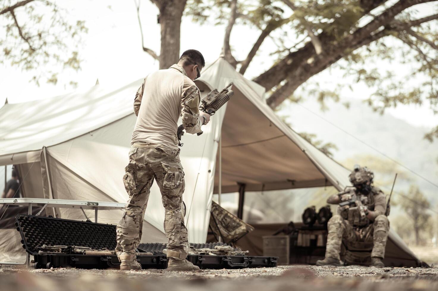 Soldiers in camouflage uniforms planning on operation in the camp, soldiers training in a military operation photo