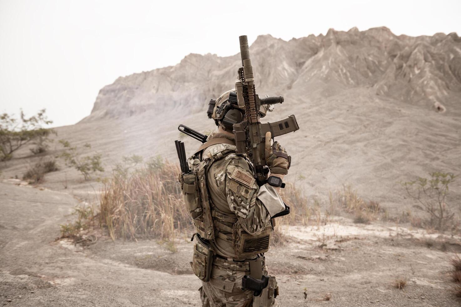 Soldiers in camouflage uniforms aiming with their riflesready to fire during military operation in the desert soldiers training in a military operation photo