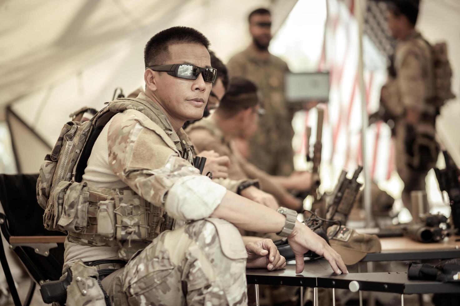 Soldiers in camouflage uniforms planning on operation in the camp, soldiers training in a military operation photo