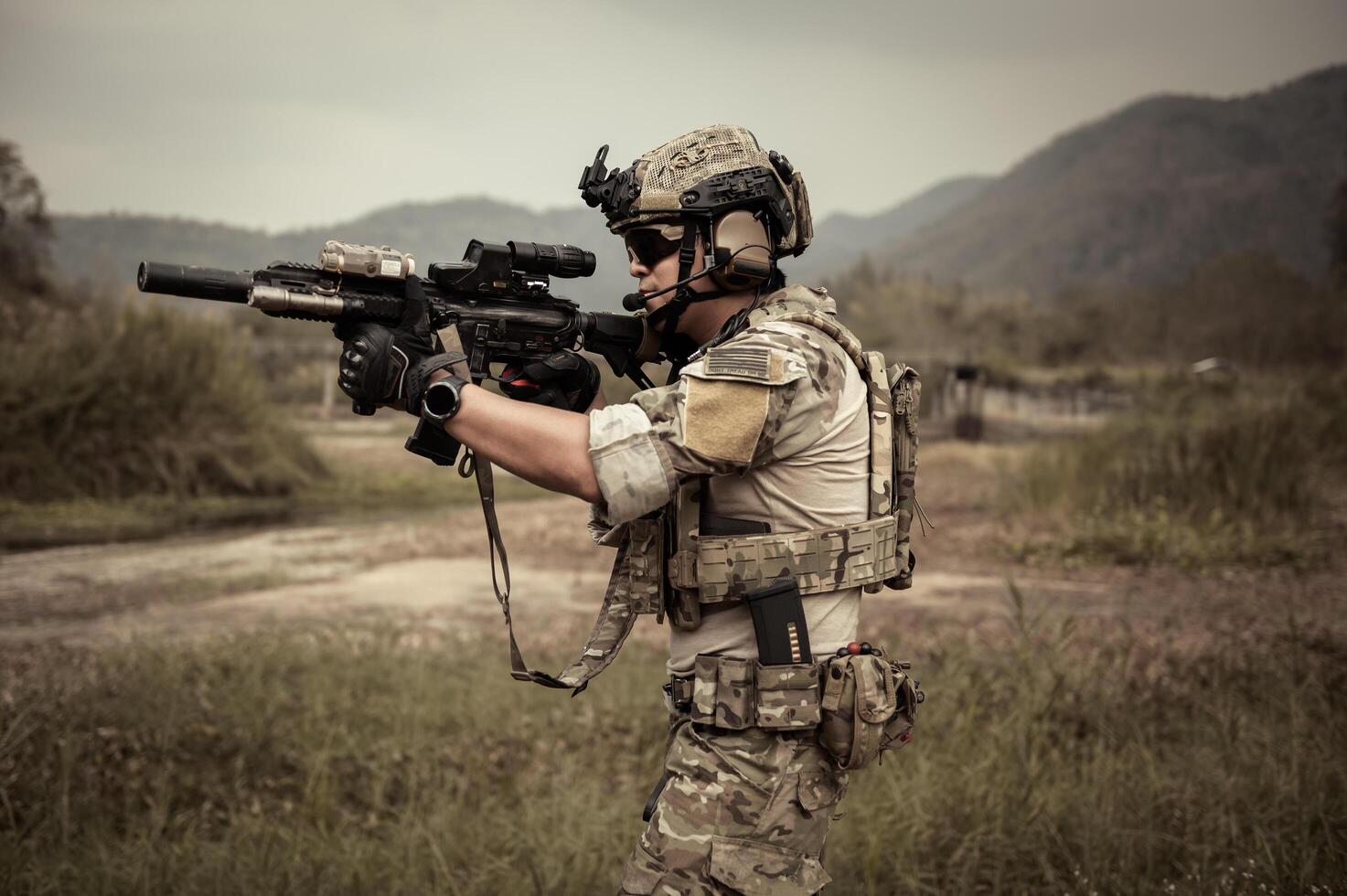 Soldiers in camouflage uniforms aiming with their riflesready to fire during Military Operation in the forest soldiers training in a military operation photo