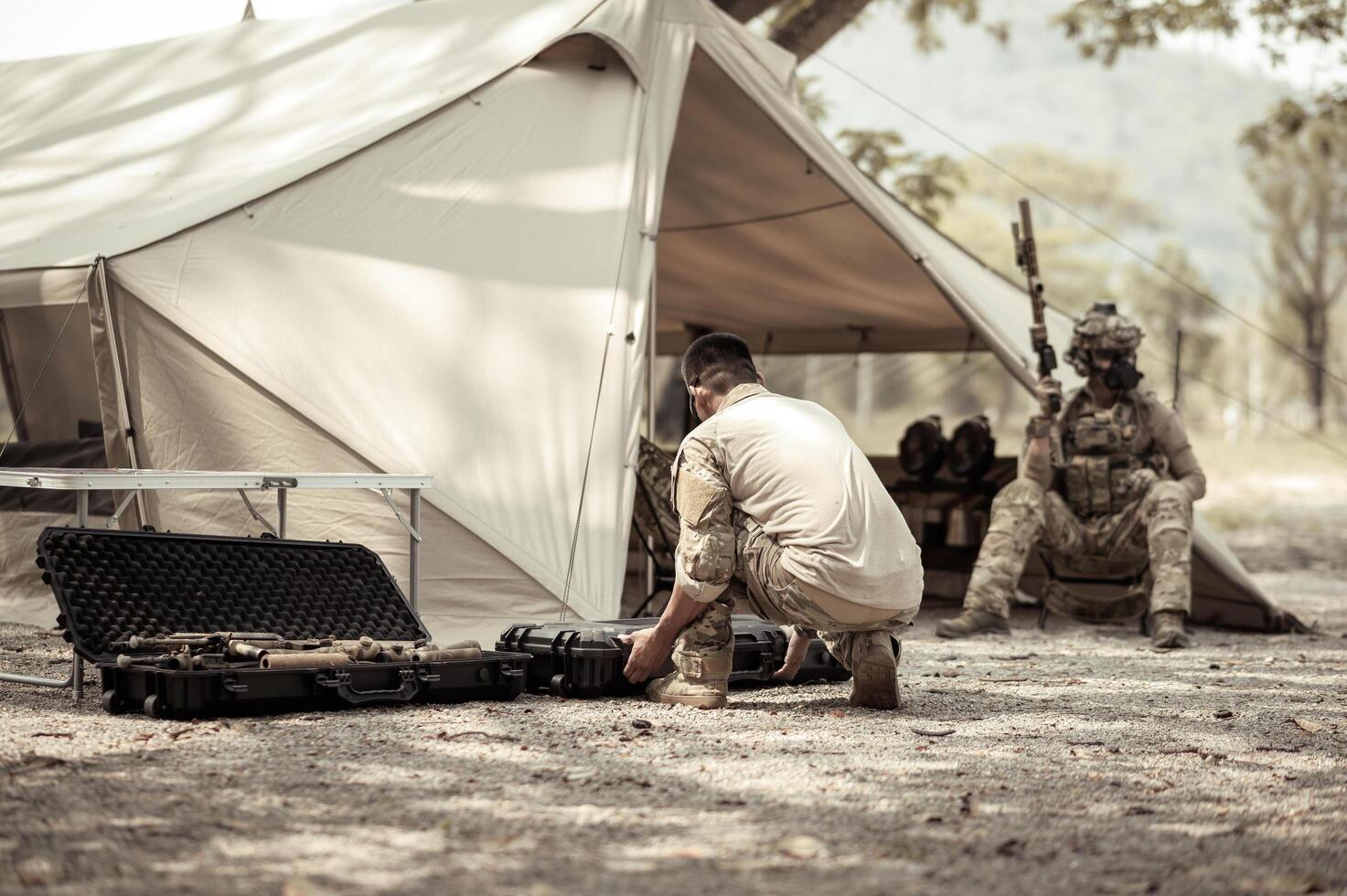 Soldiers in camouflage uniforms planning on operation in the camp, soldiers training in a military operation photo