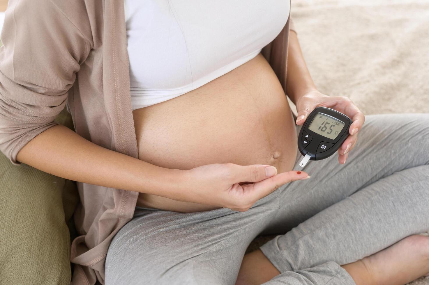 embarazada mujer comprobación sangre azúcar nivel por utilizando digital glucosa metro, salud cuidado, medicamento, diabetes, glicemia concepto foto