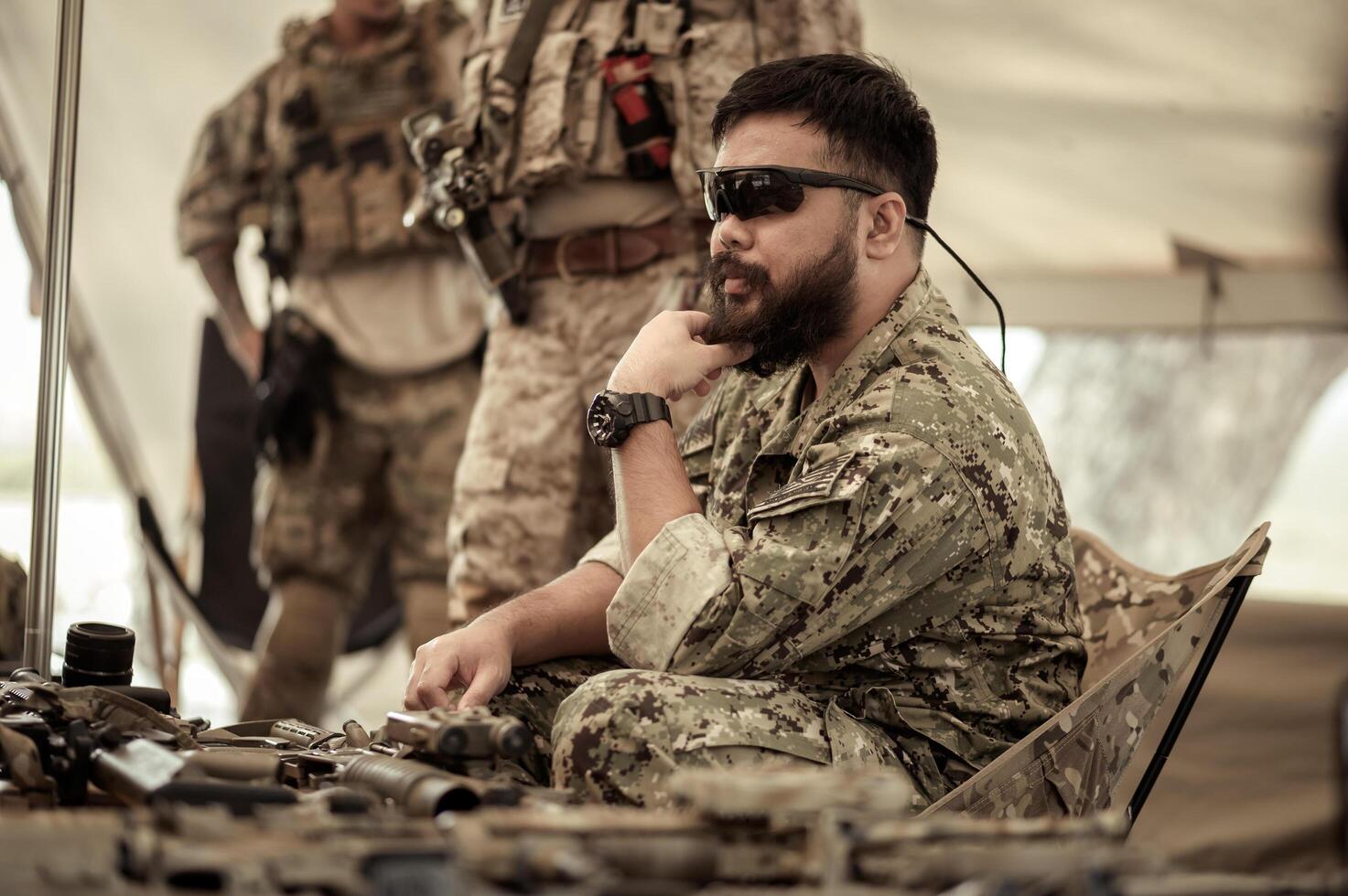 Soldiers in camouflage uniforms planning on operation in the camp, soldiers training in a military operation photo