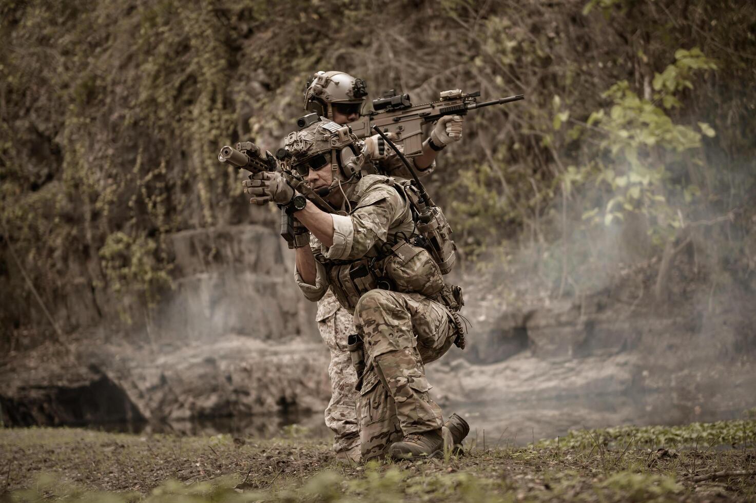 soldados en camuflaje uniformes puntería con su rifles listos a fuego durante militar operación en el bosque soldados formación en un militar operación foto