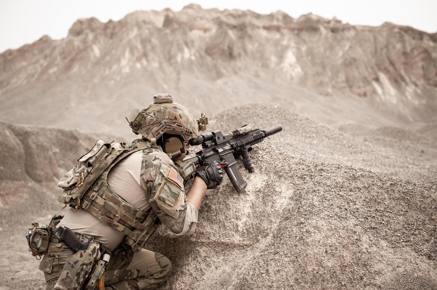 Soldiers in camouflage uniforms aiming with their riflesready to fire during military operation in the desert soldiers training in a military operation photo