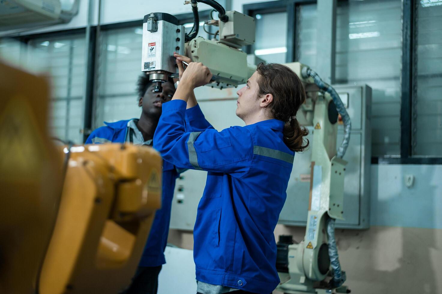 A group of Robotics engineers working with Programming and Manipulating Robot Hand, Industrial Robotics Design, High Tech Facility, Modern Machine Learning. Mass Production Automatics. photo